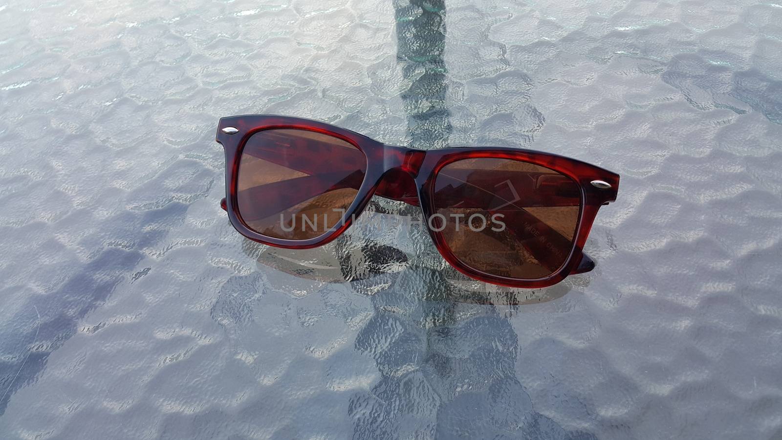 Eye glasses or spectacles on glass floor or table by Photochowk
