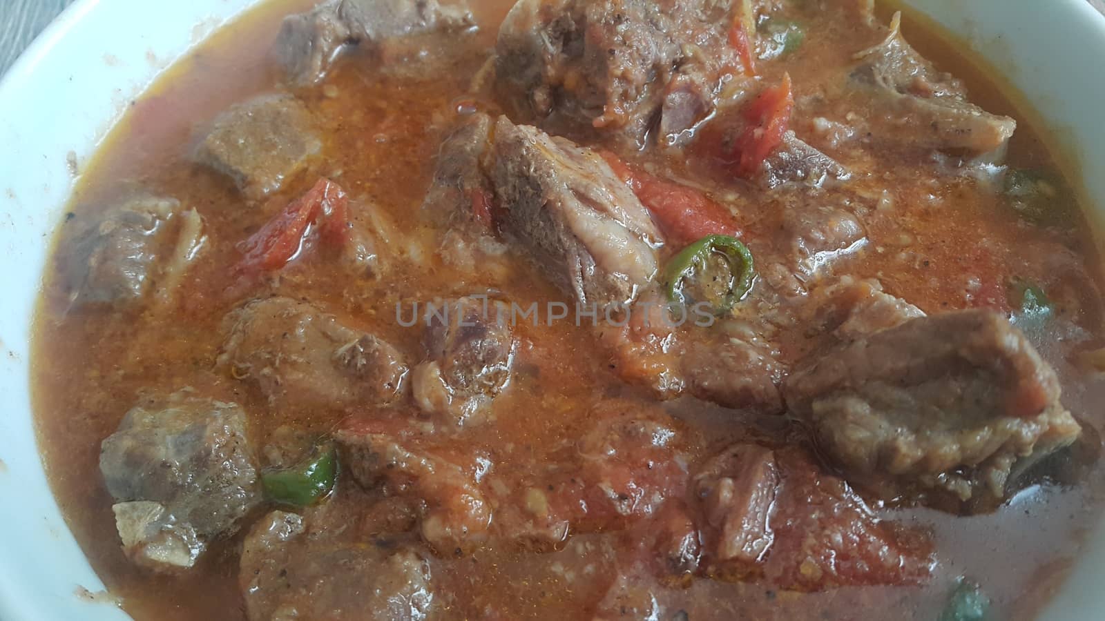 A close up view of stewed chicken meat cubes with spices on it by Photochowk