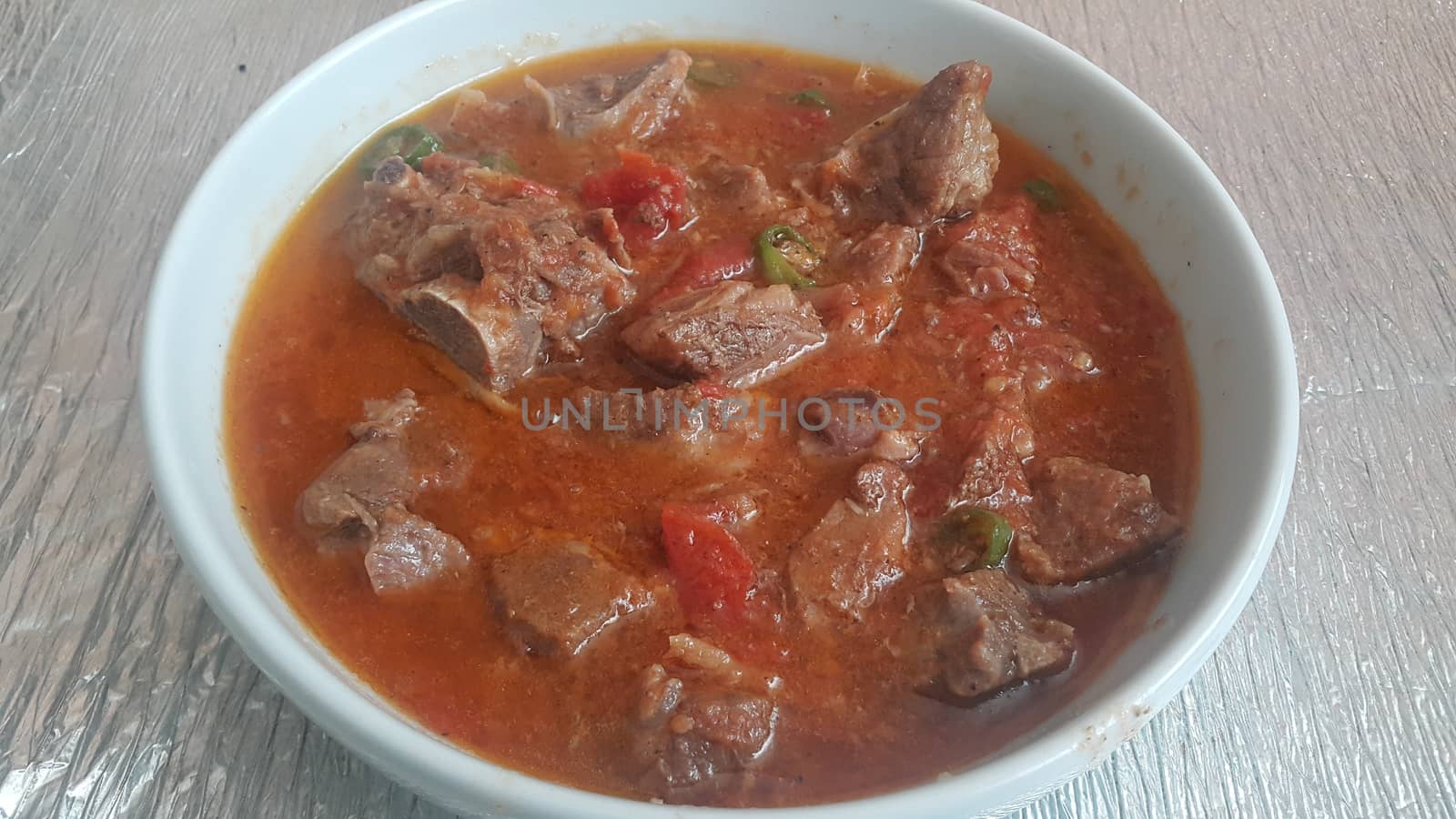 A close up view of stewed chicken meat cubes with spices on it by Photochowk