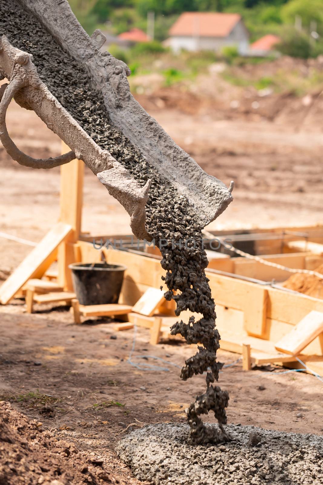 Lay of the cement or concrete into the foundation formwork with automatic pump. Building house foundation