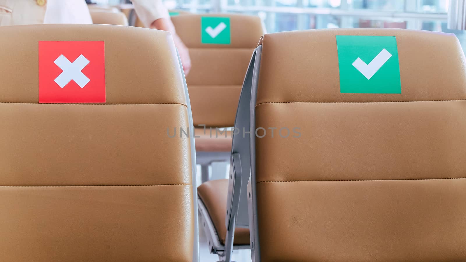 Social distancing, Rows of empty chairs in an airport's departure area marked with symbols regarding social distancing protocol to prevent the spreading of novel corona virus, COVID-19 in Thailand