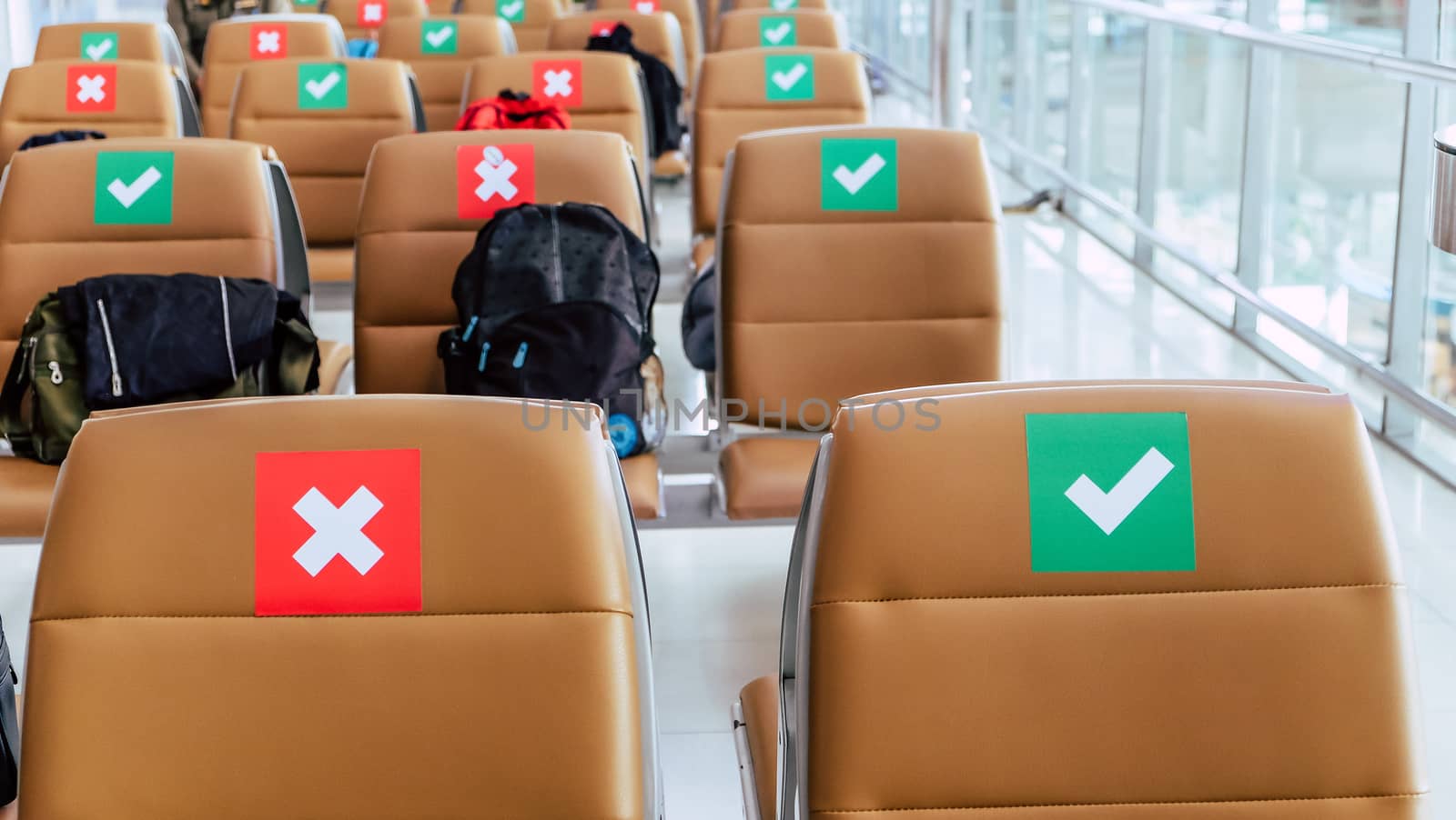 Social distancing, Rows of empty chairs in an airport's departure area marked with symbols regarding social distancing protocol to prevent the spreading of novel corona virus, COVID-19 in Thailand