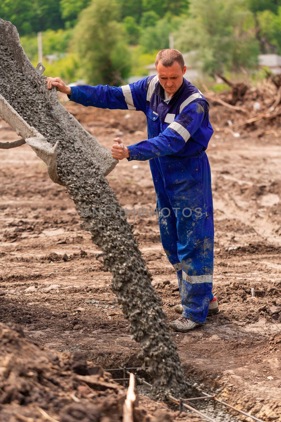 Construction worker laying cement or concrete into the foundation formwork. Building house foundation