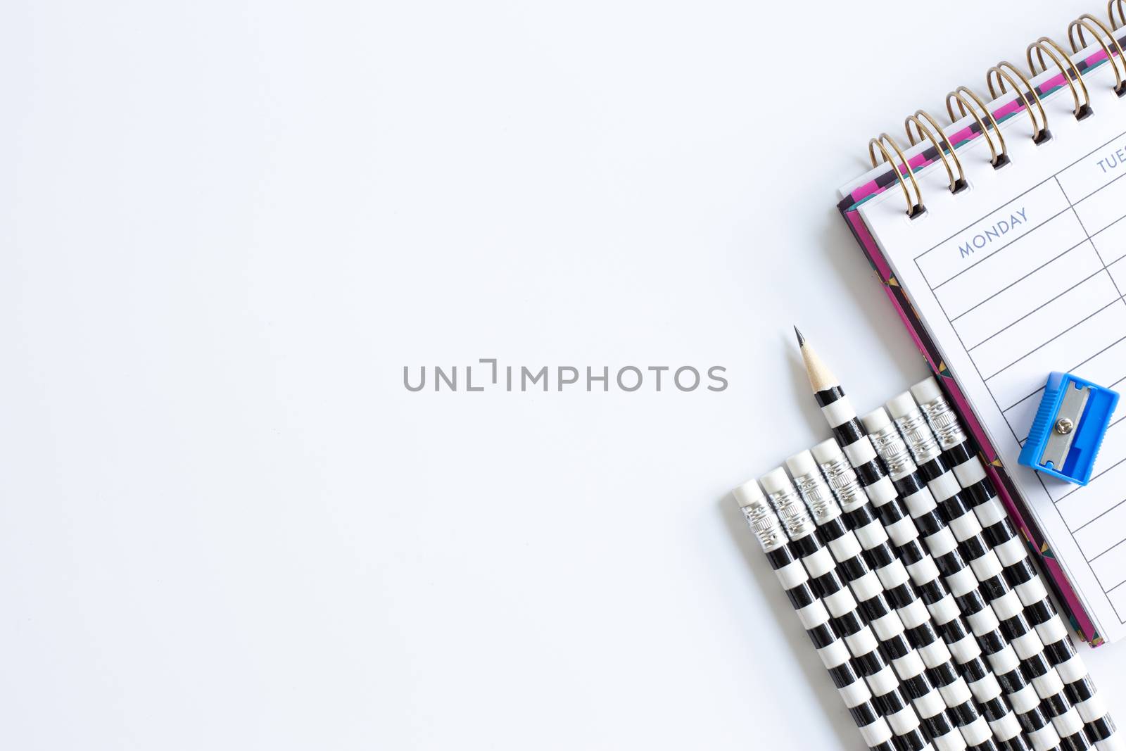 Weekly organizer planner, shaper and sharp pencil surrounded by dull pencils. Stationery flat lay. Back to school. White background. Business, sharp idear concept. Mock up