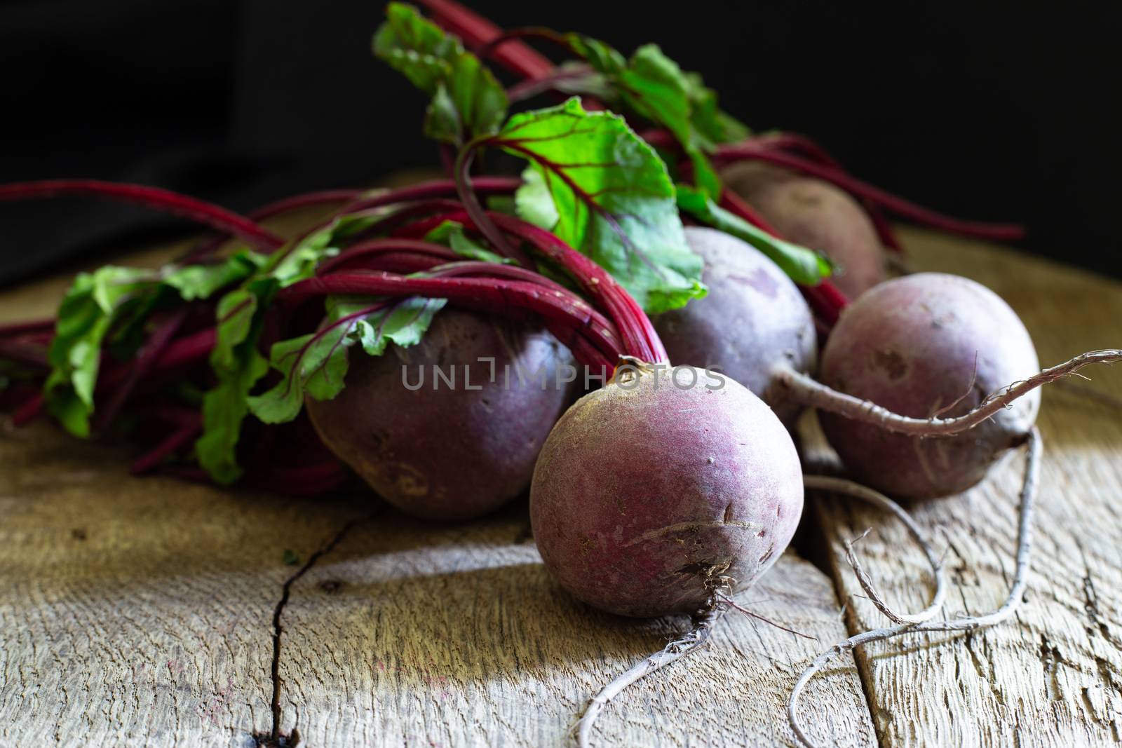 Bunch of fresh, spring, organic beetroot on old wooden background. Horisontal view. Rustic, dramatic, organic kitchen. Ingredients, menu. Healthy life, diet concept