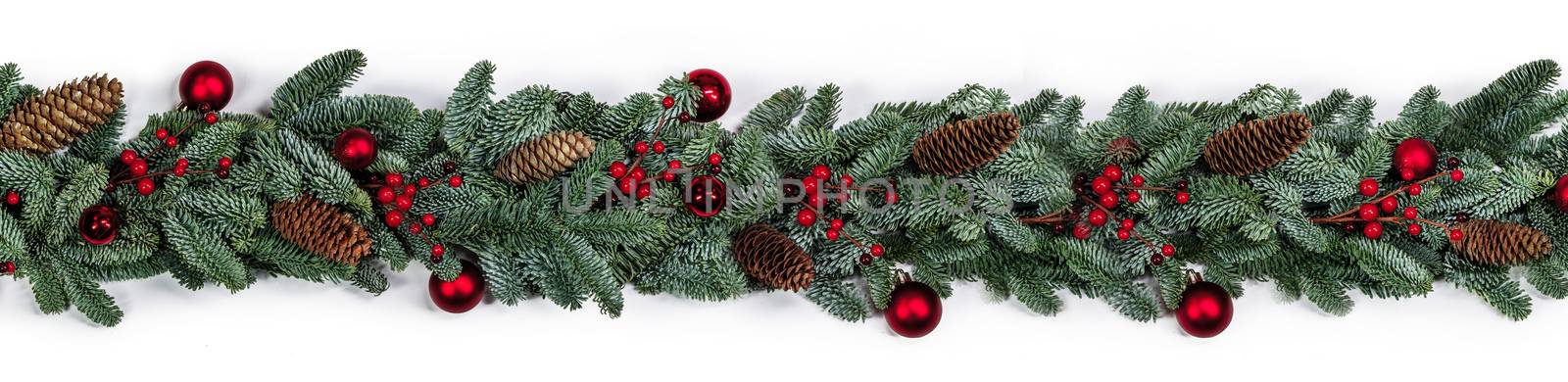 Christmas border frame stripe design copmosition of noble fir tree branch and red decorations balls baubles berries cones isolated on white background
