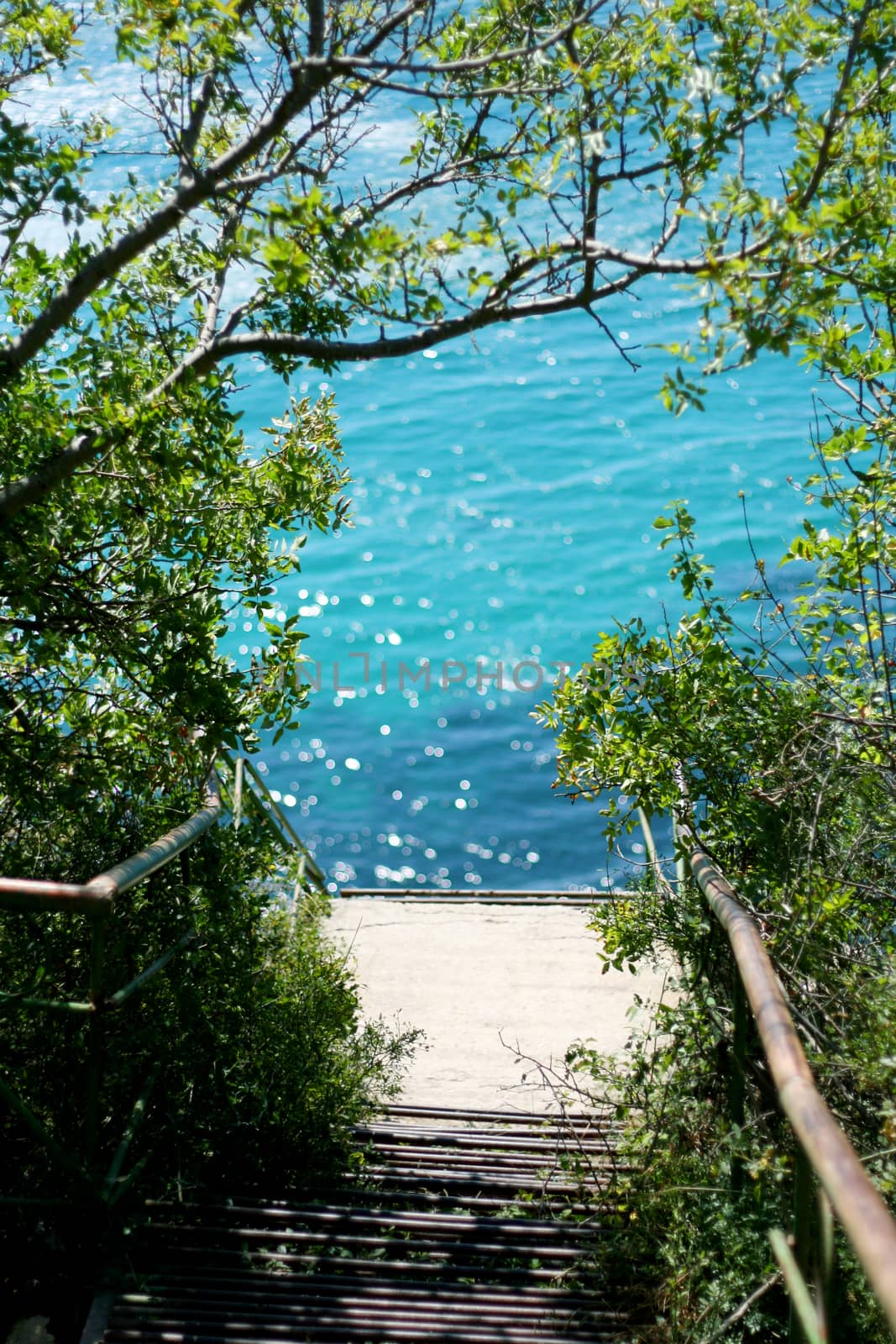 Steps to the sea shore with azure water.