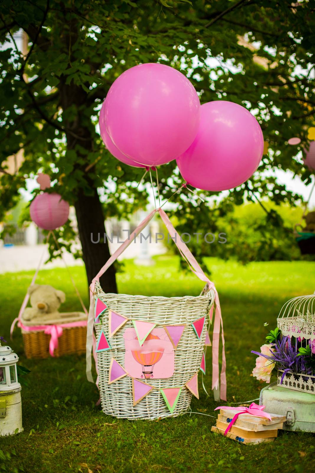 street decorations for a children's party. Wicker baskets with balloons in a green park.