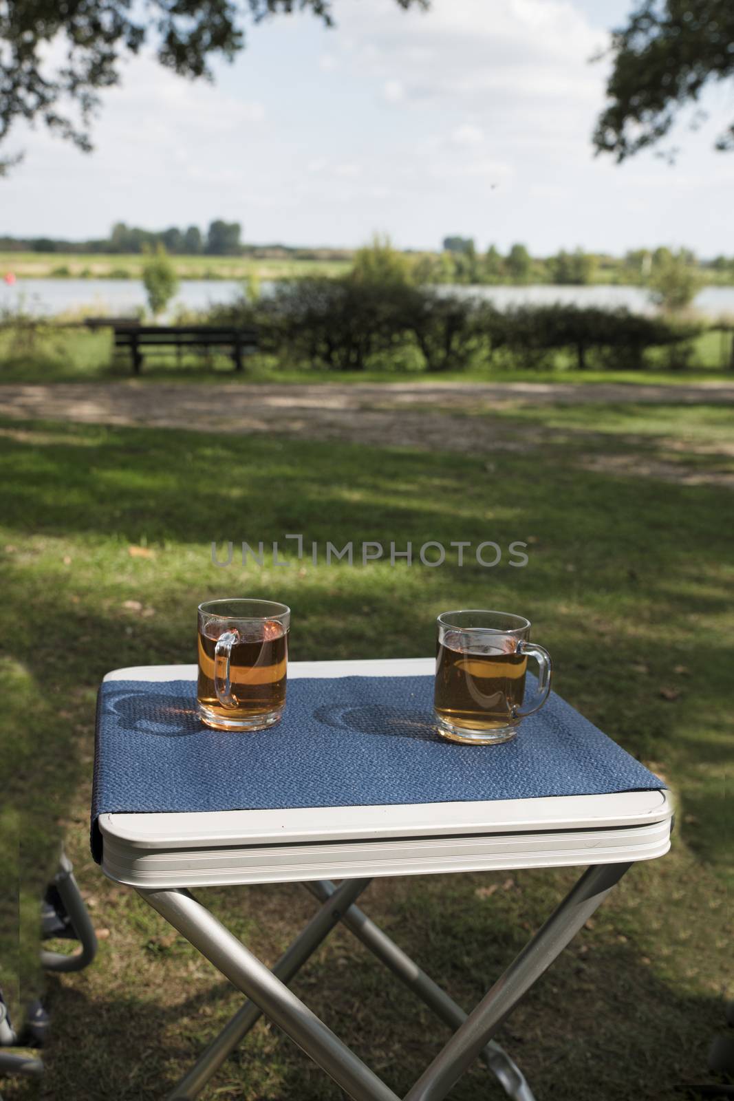 two glasses of tea outside on a table on the river Maas by compuinfoto