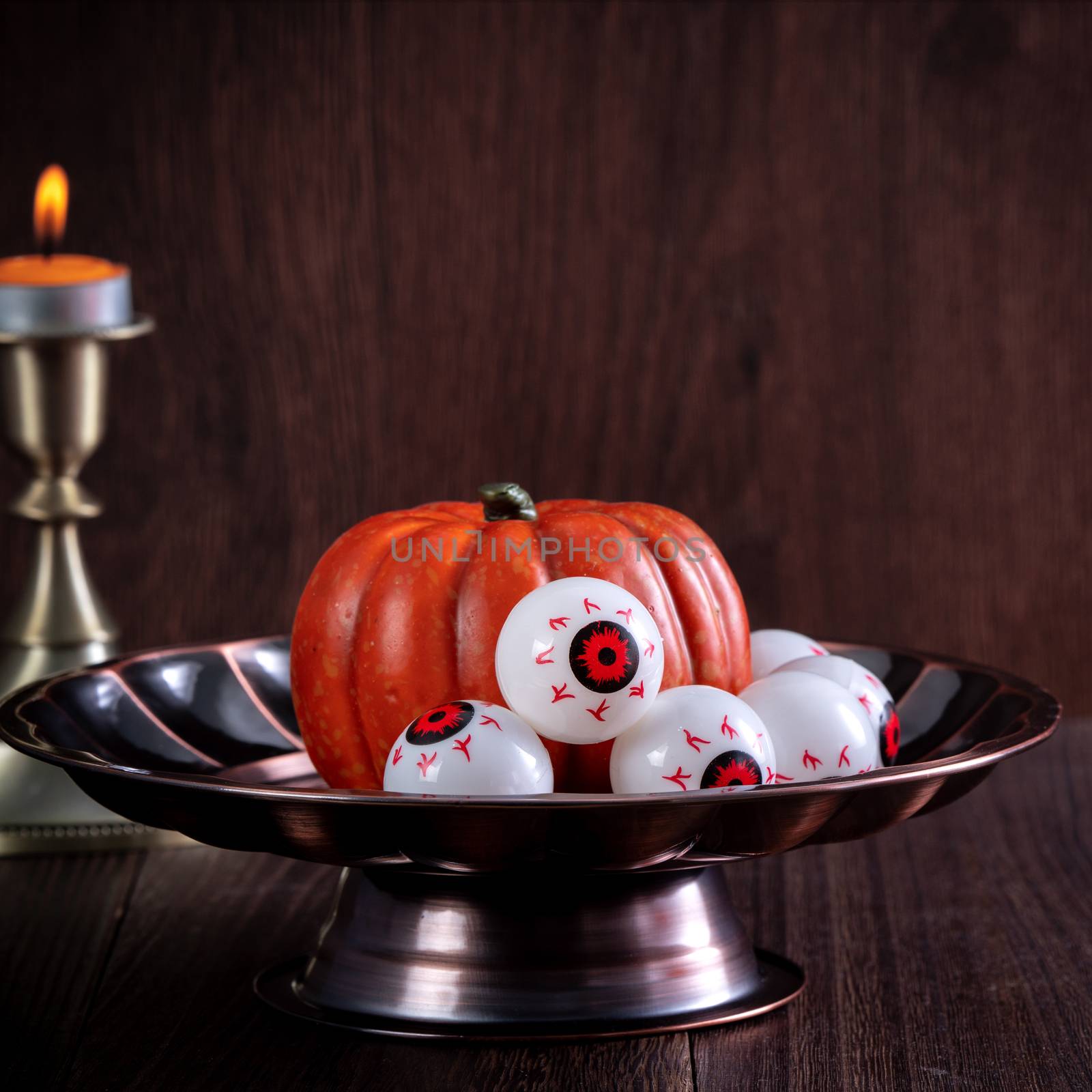 Spooky Halloween decor, horror festival concept, pumpkin lantern with candlestick.
