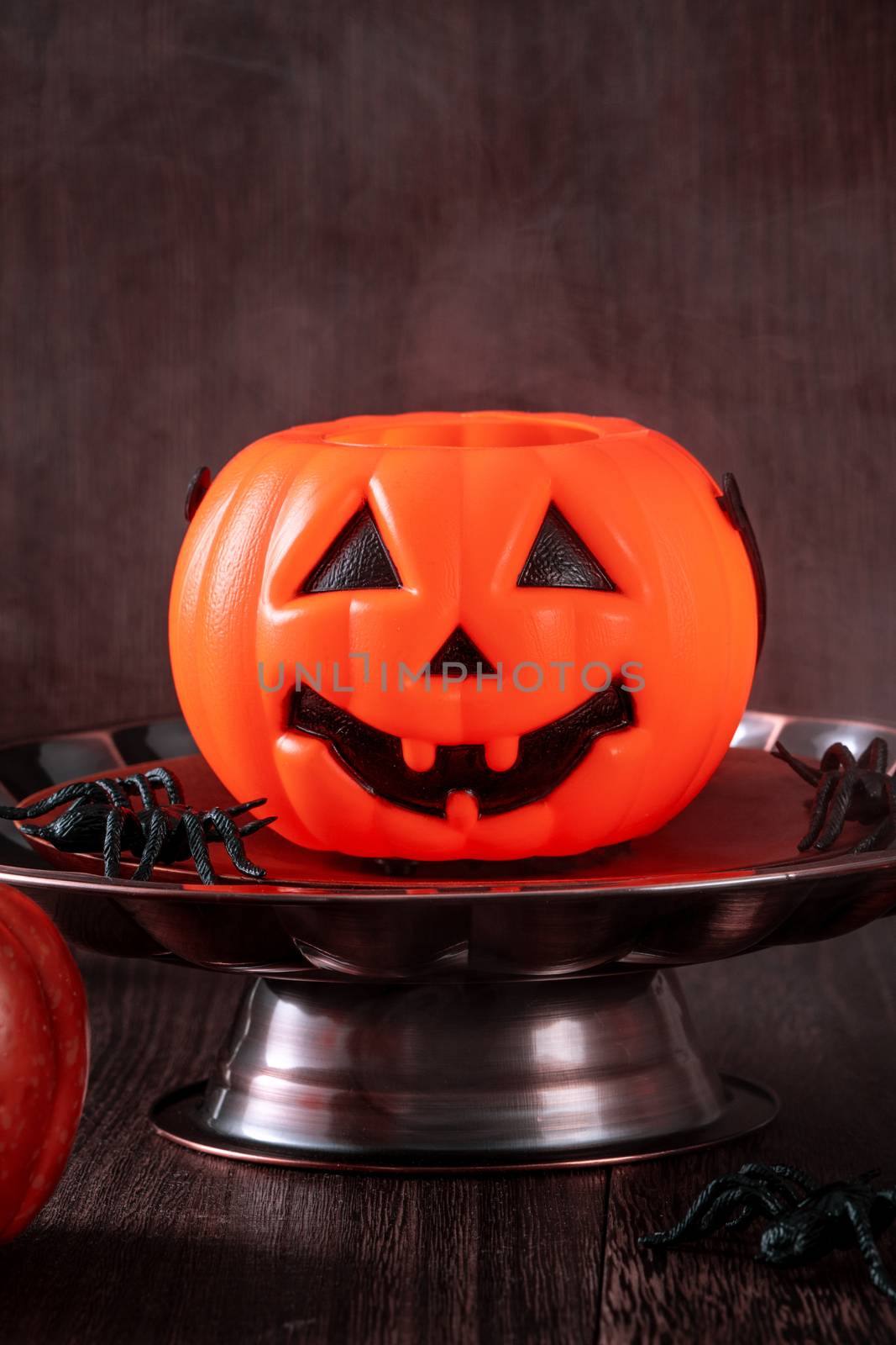 Spooky Halloween decor, horror festival concept, pumpkin lantern with candlestick.