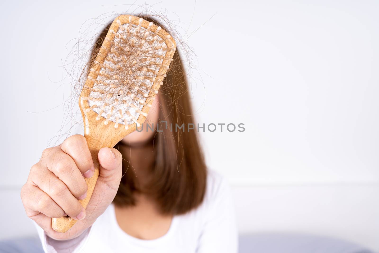 Hair fall problem, closeup hand holding comb and problem hair. Healthcare medical or daily life concept. by mikesaran