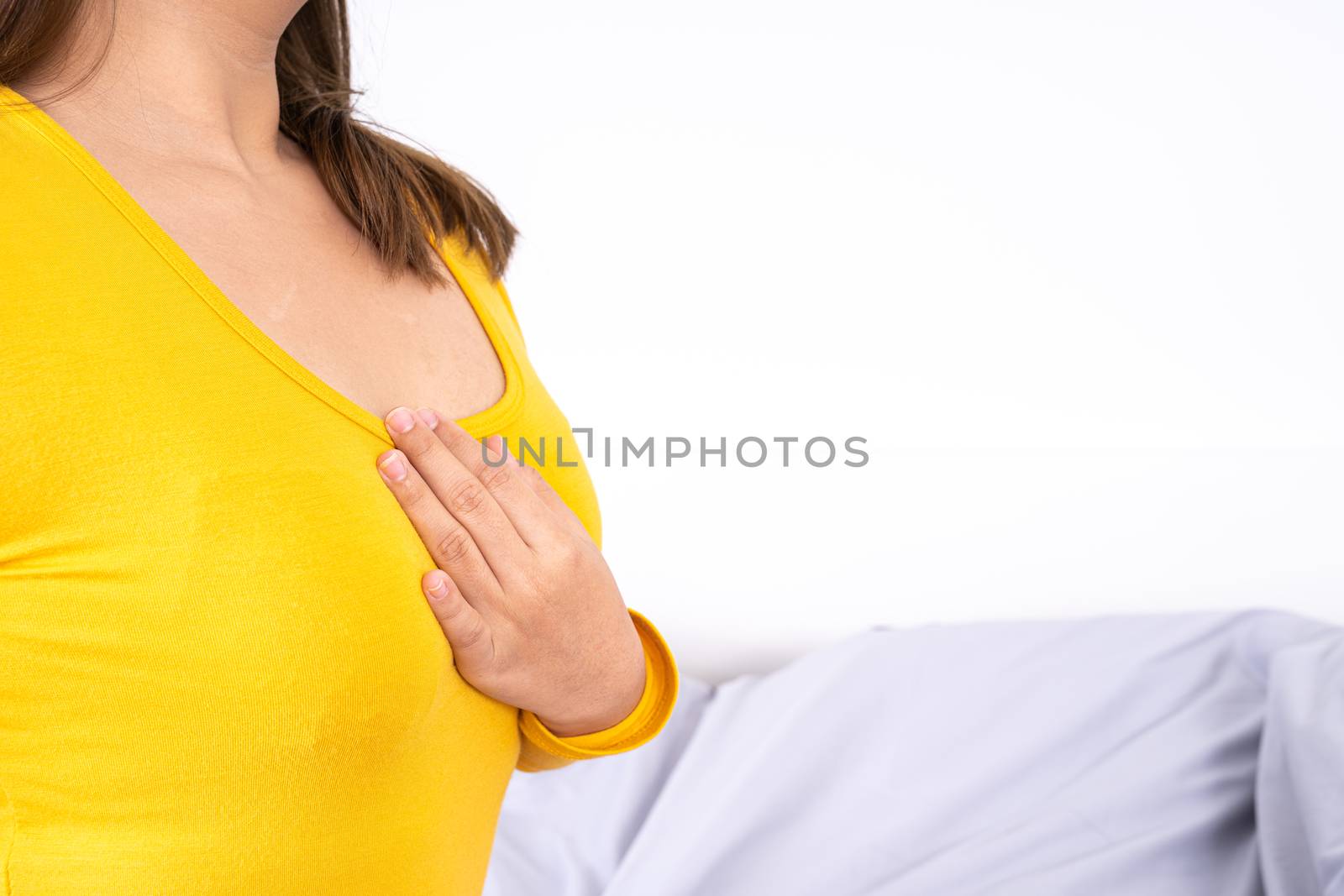 Young woman suffering from chest pain after wake up on the bed. Healthcare medical or daily life concept.