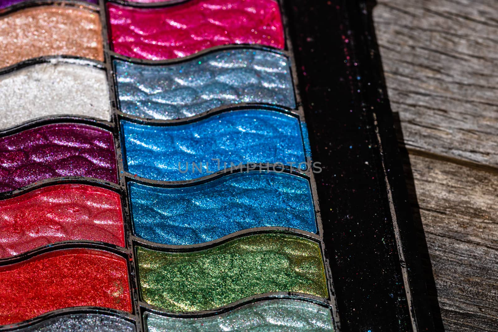 Make up eyeshadow palette close up isolated on wooden background by vladispas