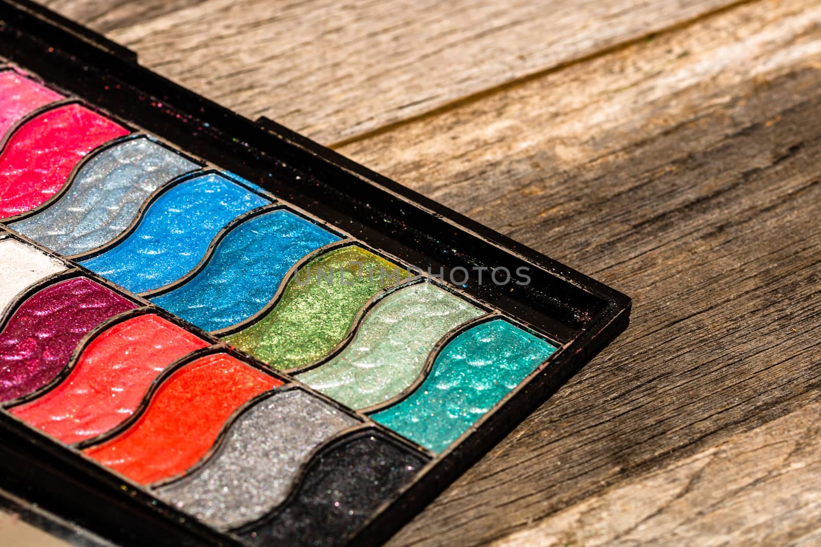 Make up eyeshadow palette close up isolated on wooden background by vladispas