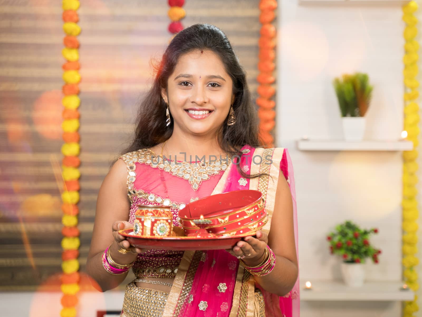 Portrit Shot of Indian Married woman in traditional dress holding Karva Chauth Thali or plate during Hindu Indian religious karwa chauth festival. by lakshmiprasad.maski@gmai.com