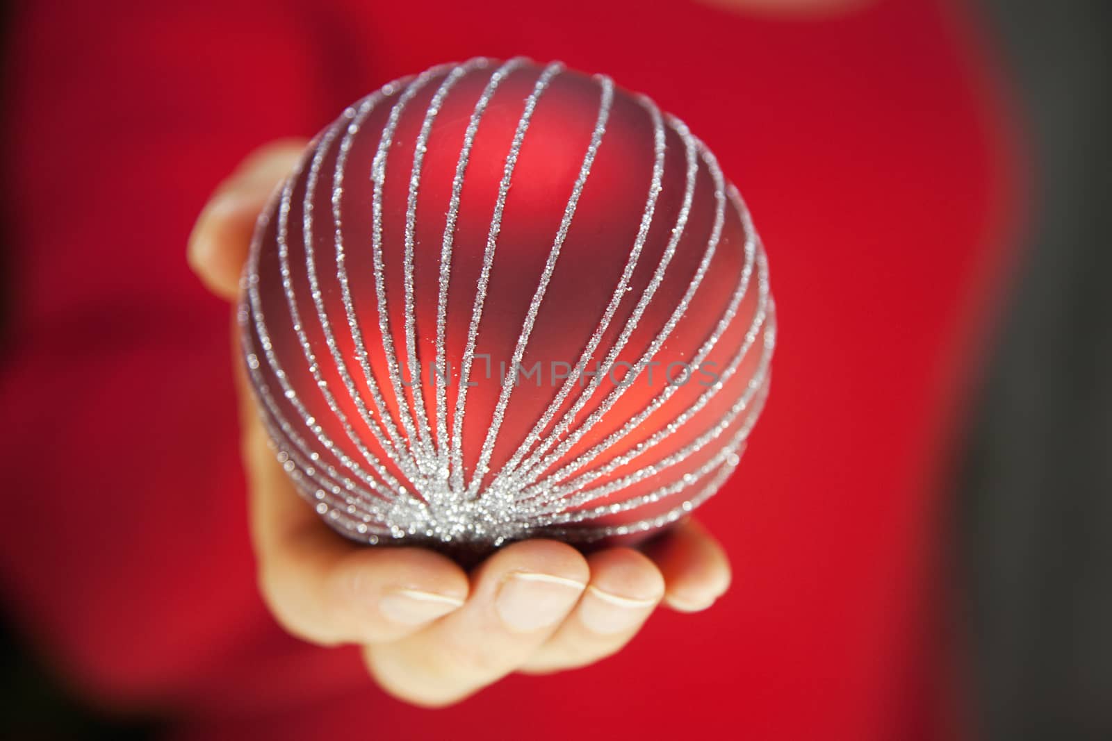 Hand holding red Christmas decoration