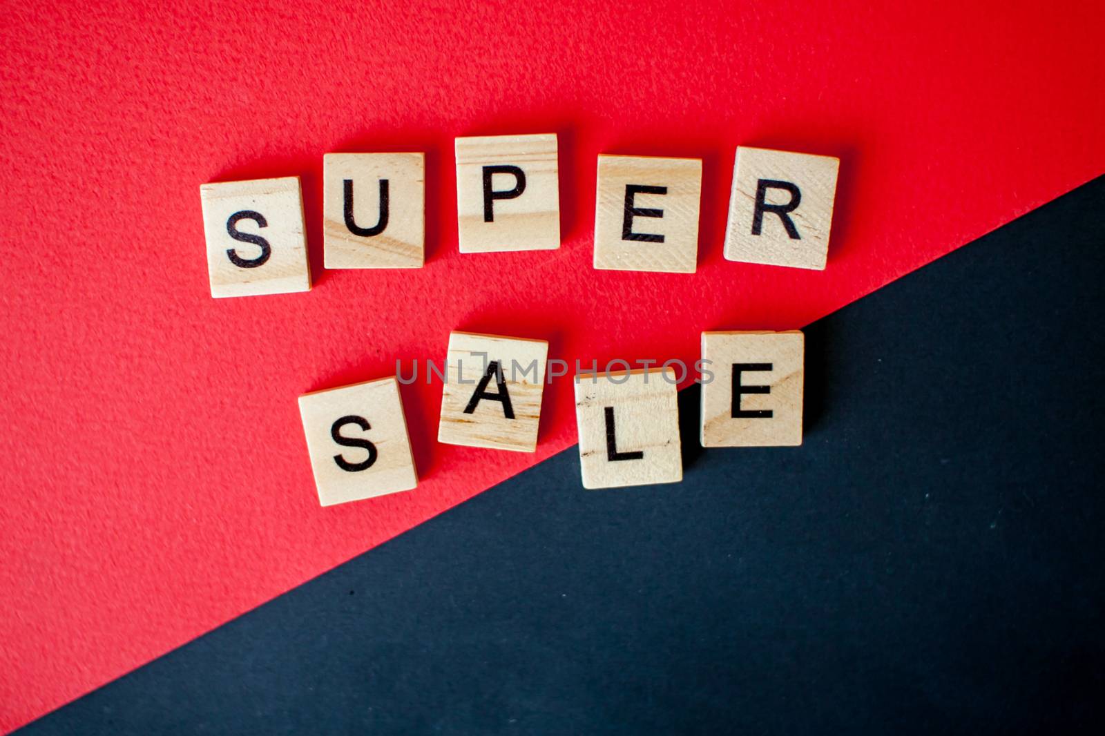 The inscription super sale from wooden blocks on a black and red background