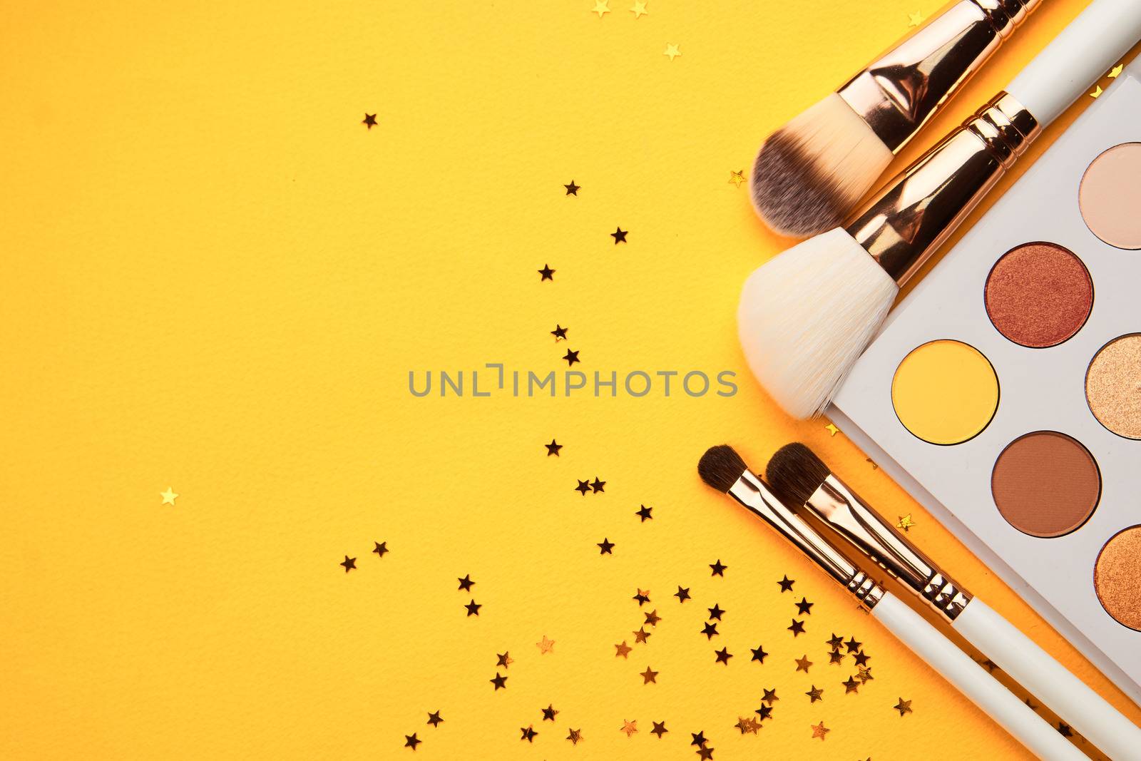 Eyeshadows and brushes for makeup glitter yellow background professional cosmetics by SHOTPRIME