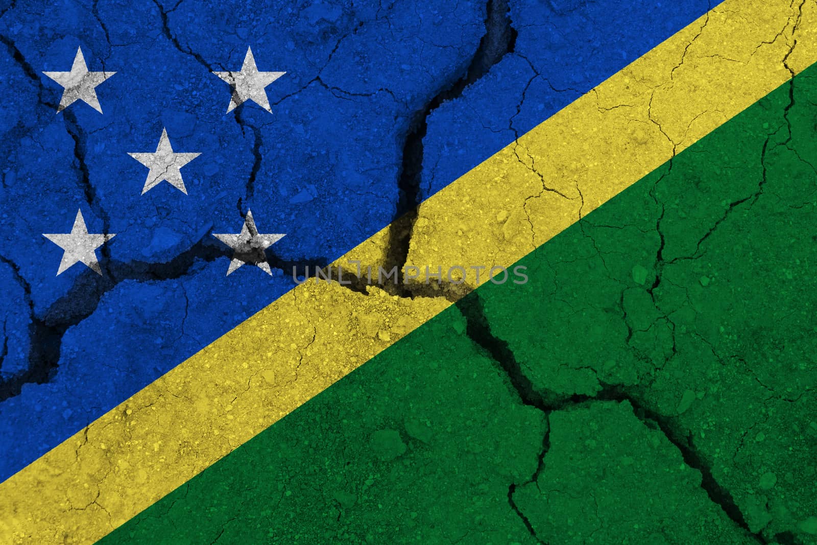 Solomon Islands flag on the cracked earth. National flag of Solomon Islands. Earthquake or drought concept