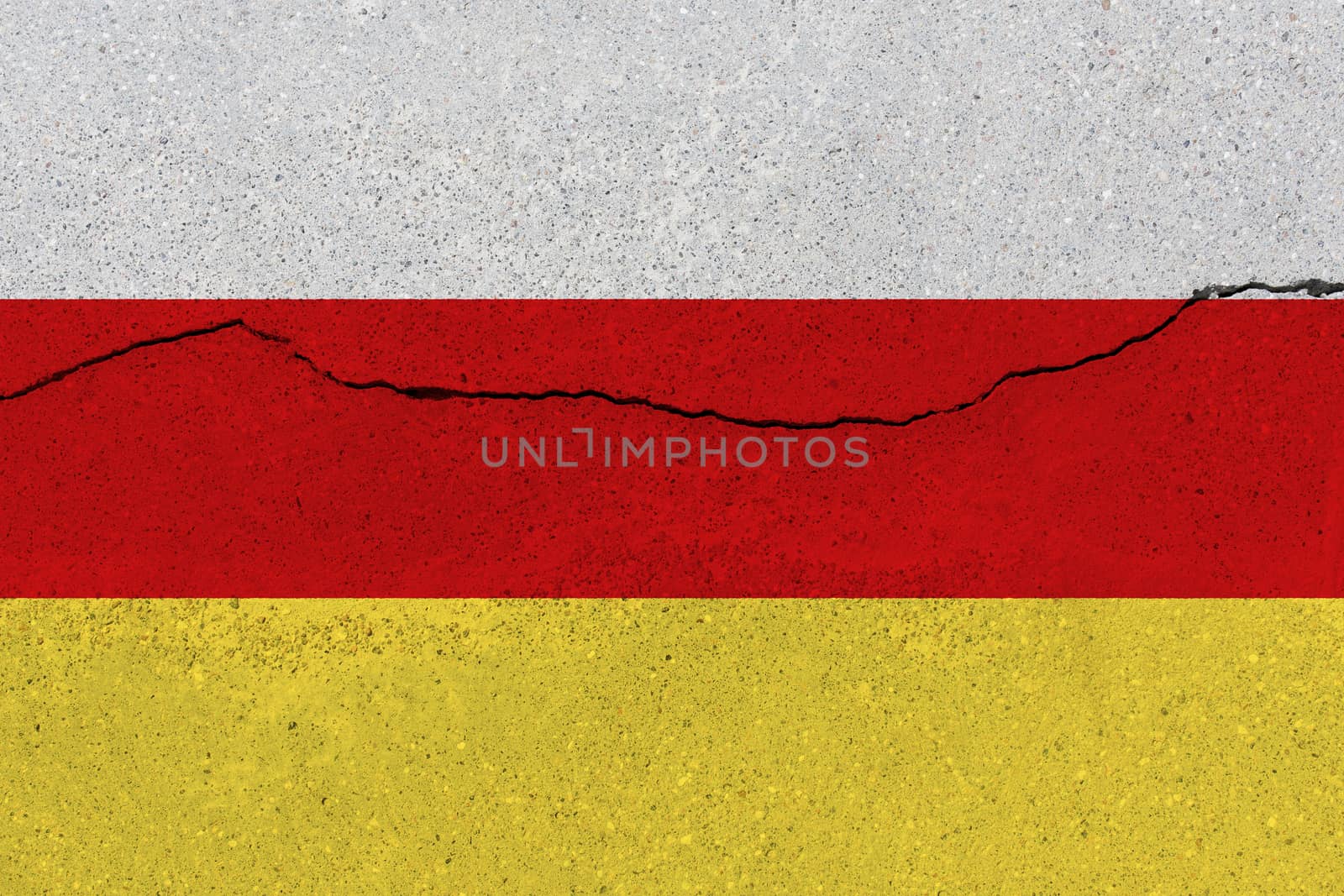 South ossetia flag on concrete wall with crack. Patriotic grunge background. National flag of South ossetia