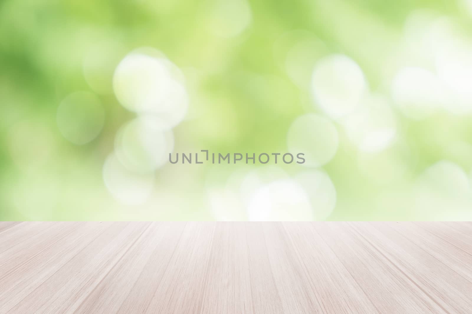 Empty wooden table top with blurred defocus natural green bokeh background, aesthetic creative design