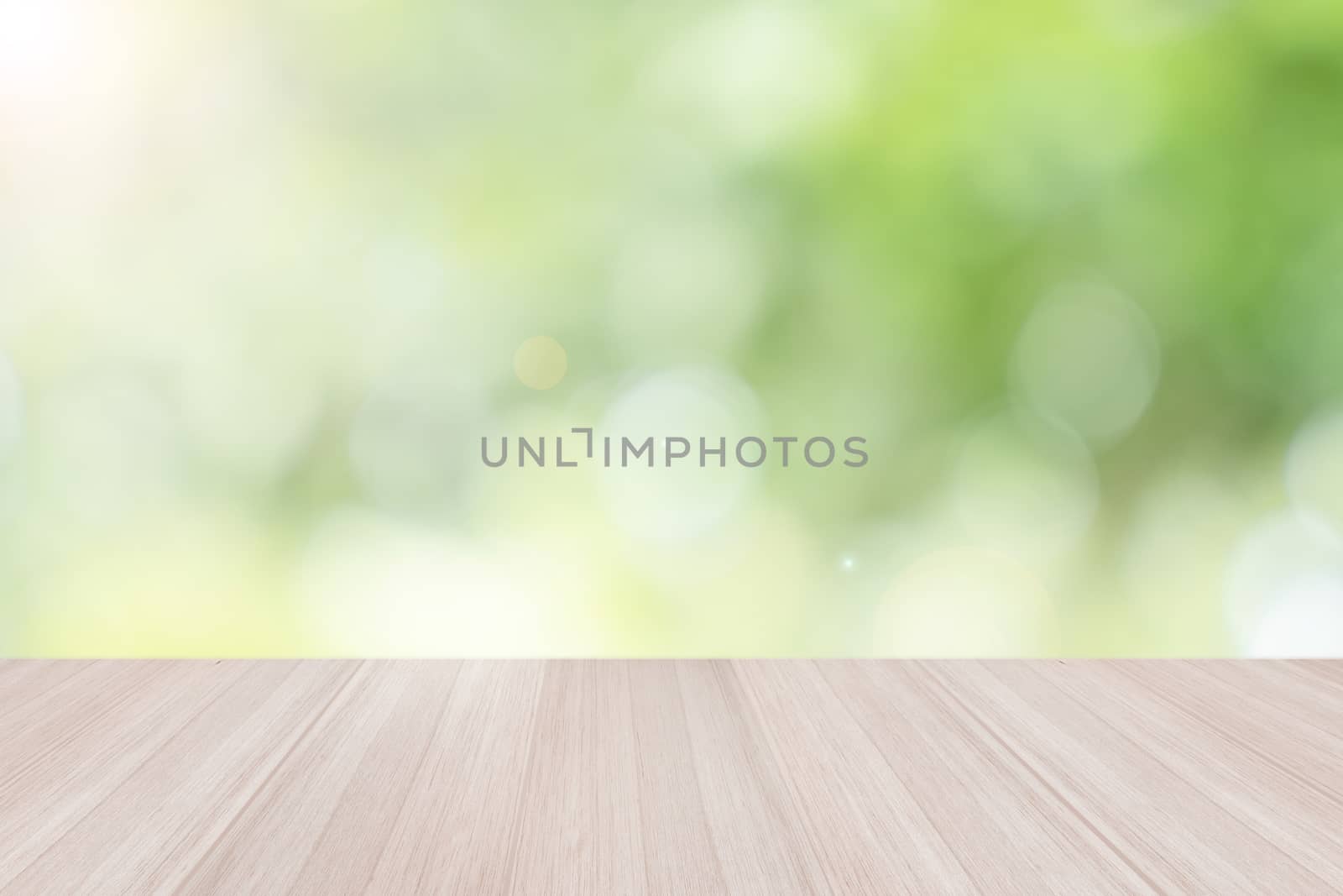 Empty wooden table top with blurred defocus natural green bokeh background, aesthetic creative design