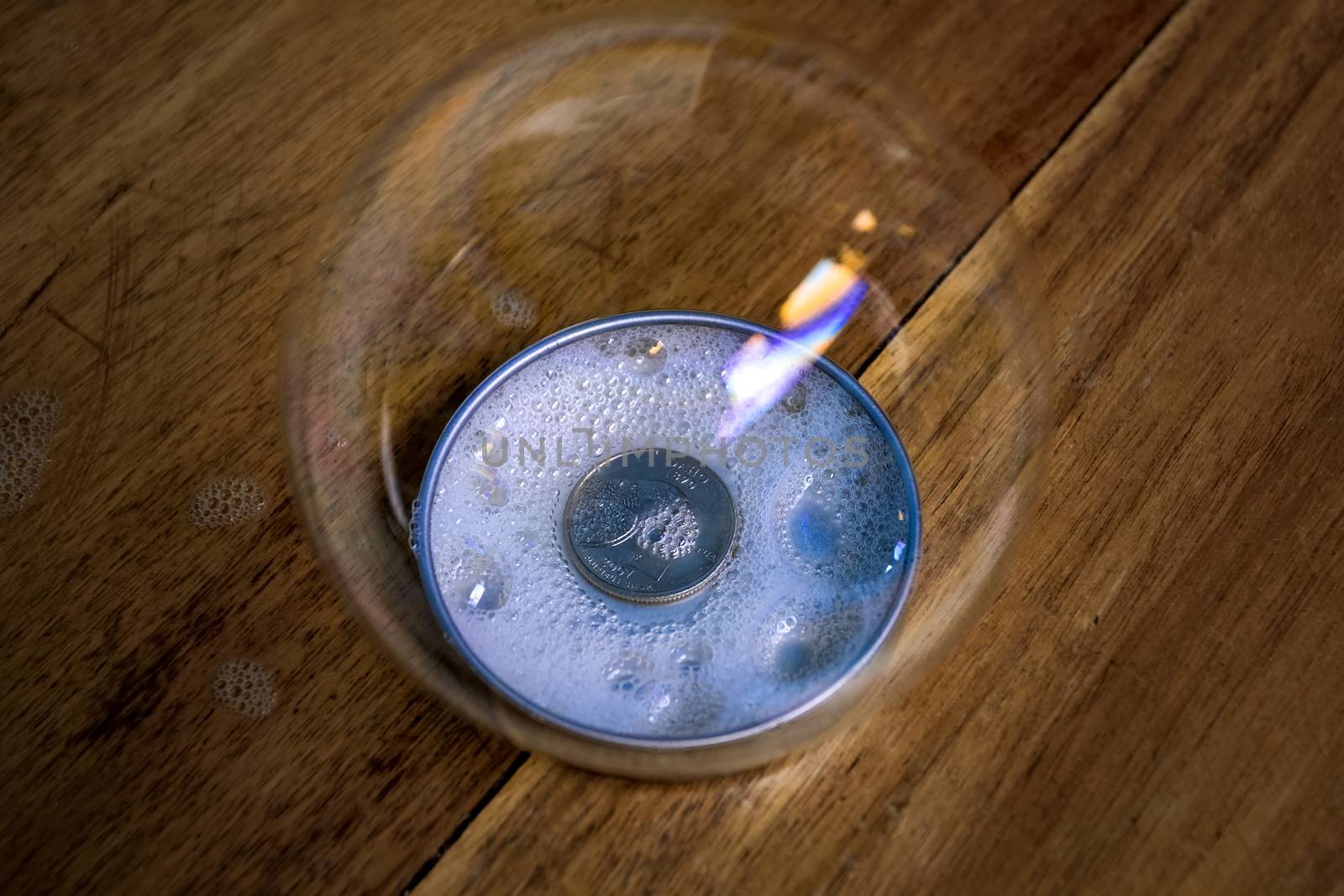 A coin in a container with foam, all covered by a large bubble