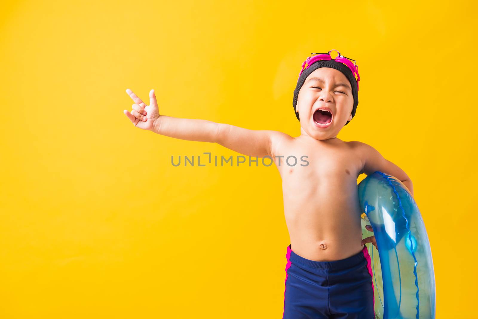 Child boy wearing goggles and swimsuit holding beach blue inflat by Sorapop