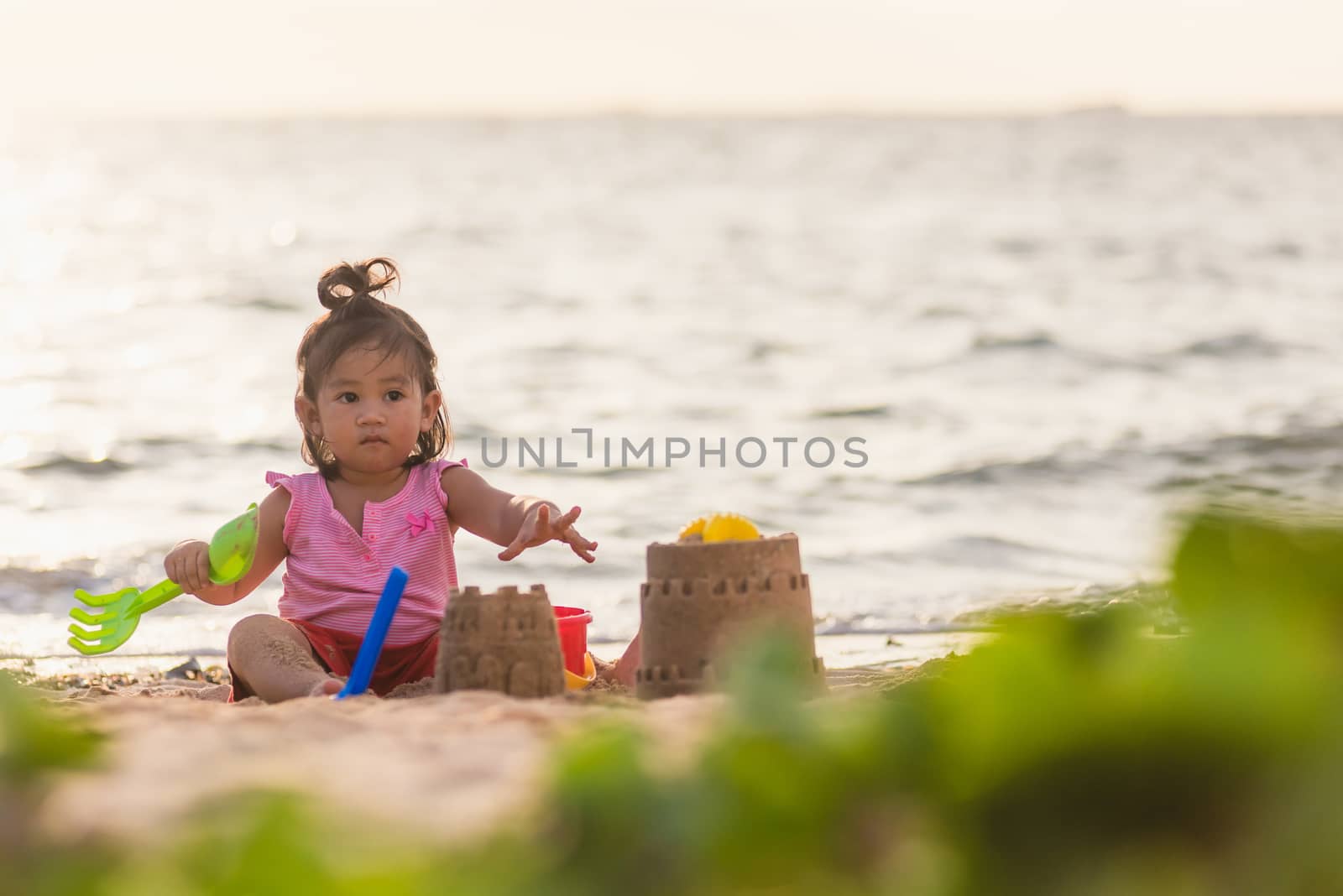 cute little girl playing sand with toy sand tools by Sorapop