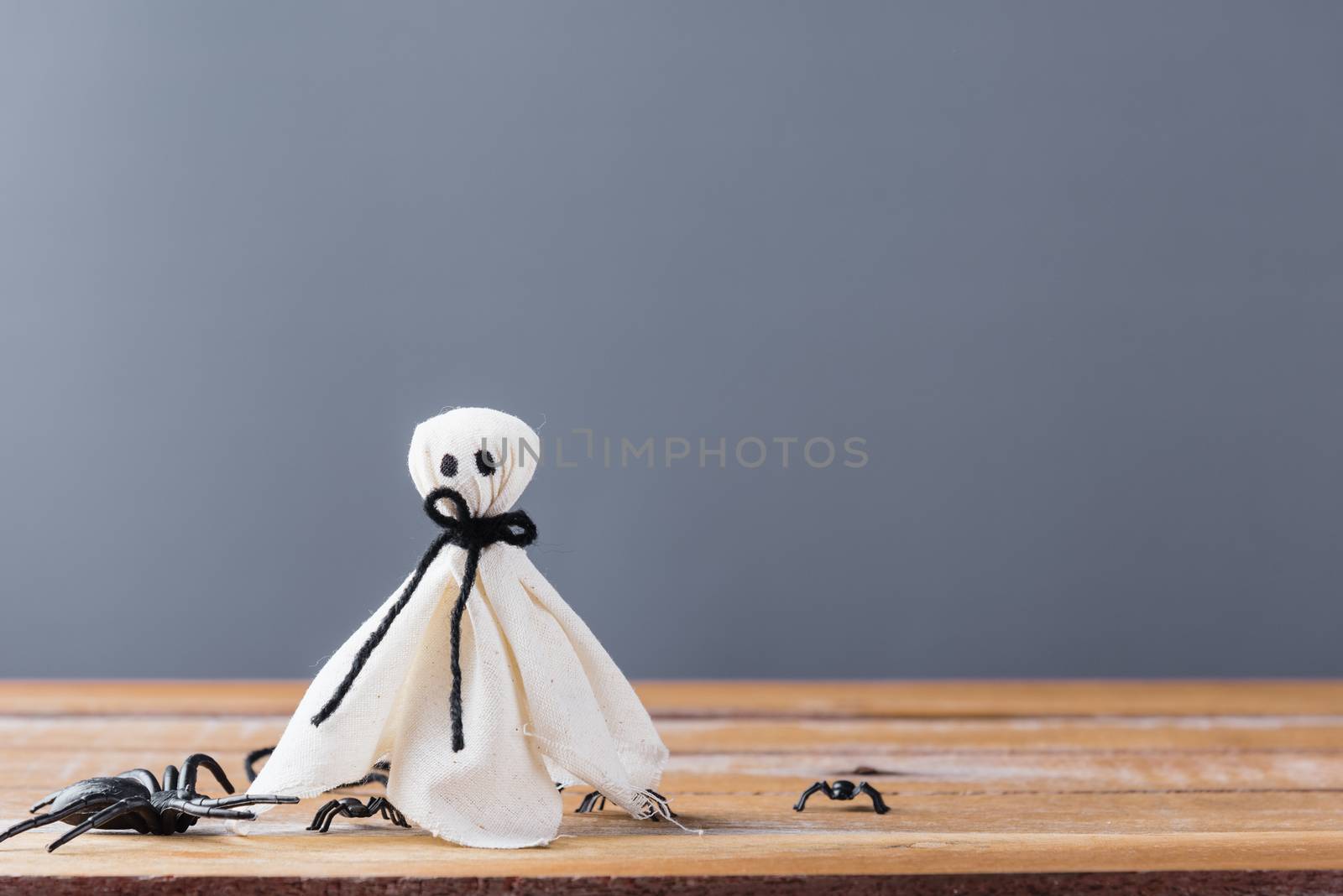 Funny Halloween day decoration party, closeup white ghost and spider on wooden wall gray background and copy space, studio shot isolated, Happy holiday concept