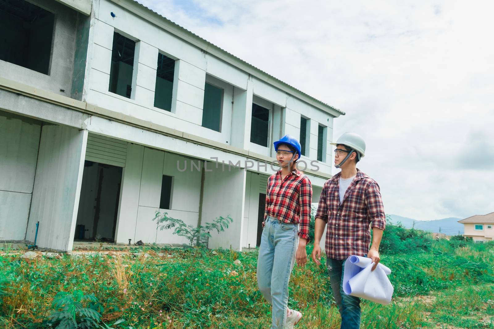 Young asian couple foreman engineering home inspection building house Walk home inspection with looking and pointing construction for check building home on job site to customers with new normol coronavirus covid-19