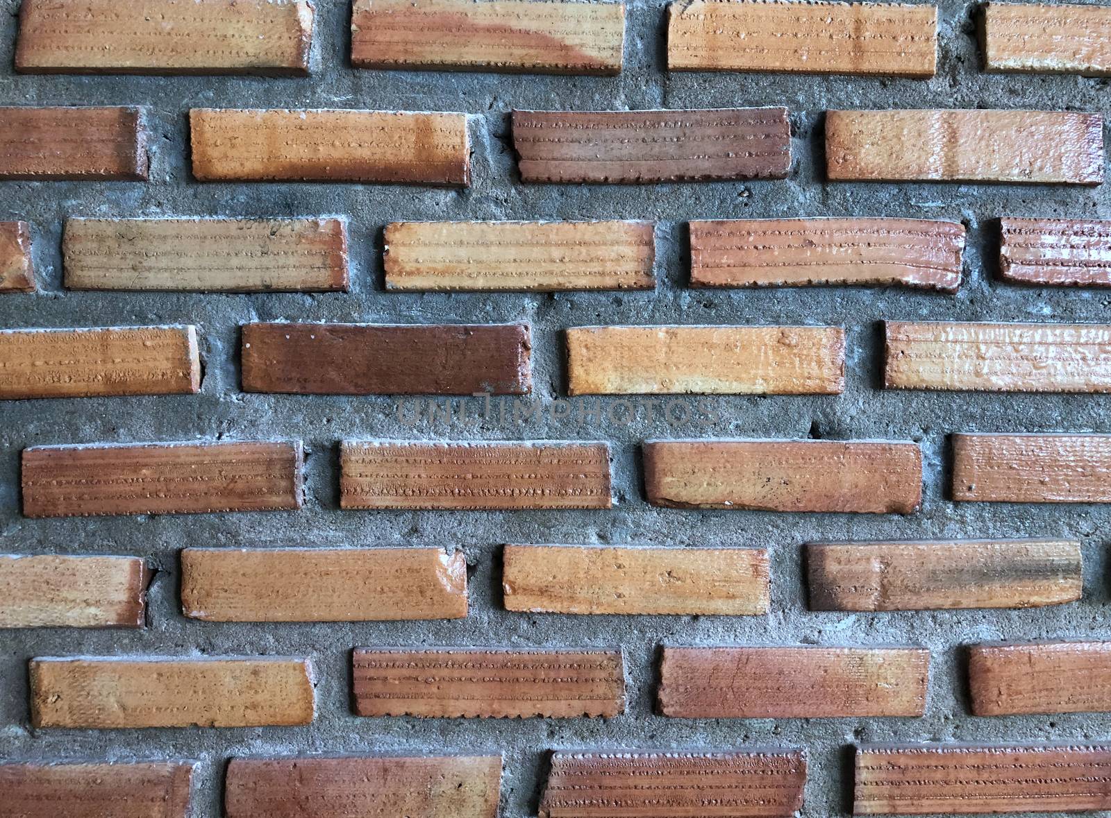 Abstract, imperfectly built brick wall with rough plaster.