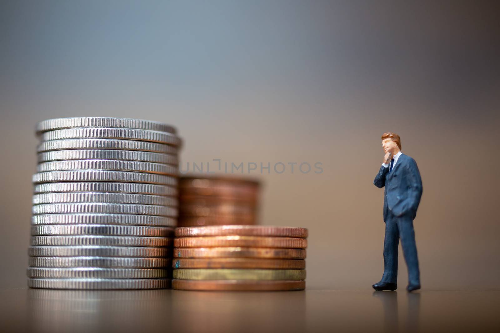 Miniature people: Small businessmen standing with stack of coins , Business Growth concept.