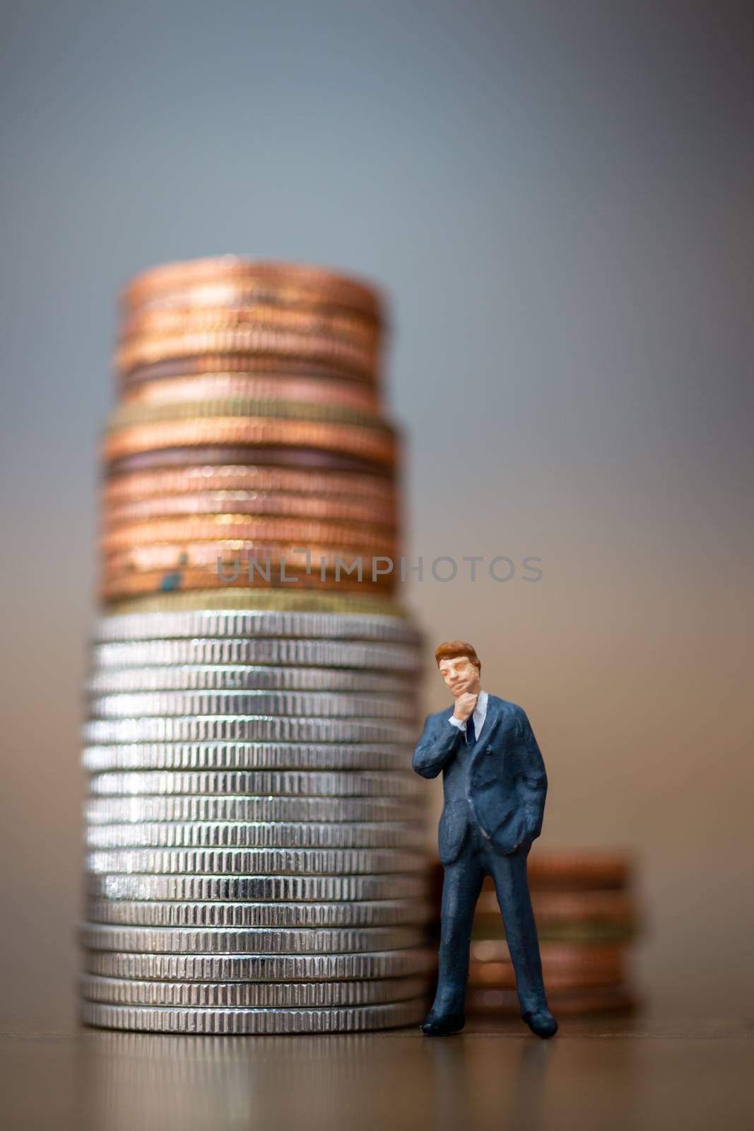 Miniature people: Small businessmen standing with stack of coins , Business Growth concept.