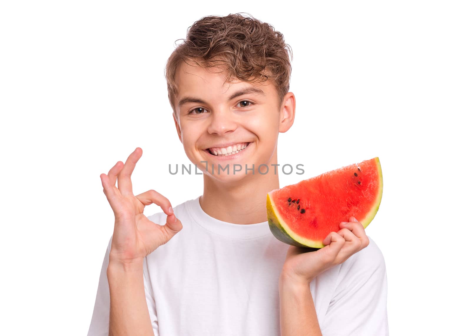 Portrait of teen boy eating ripe juicy watermelon and smiling.