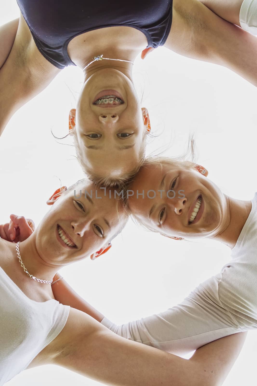 Low angle view of attractive positive girls standing together by Digoarpi
