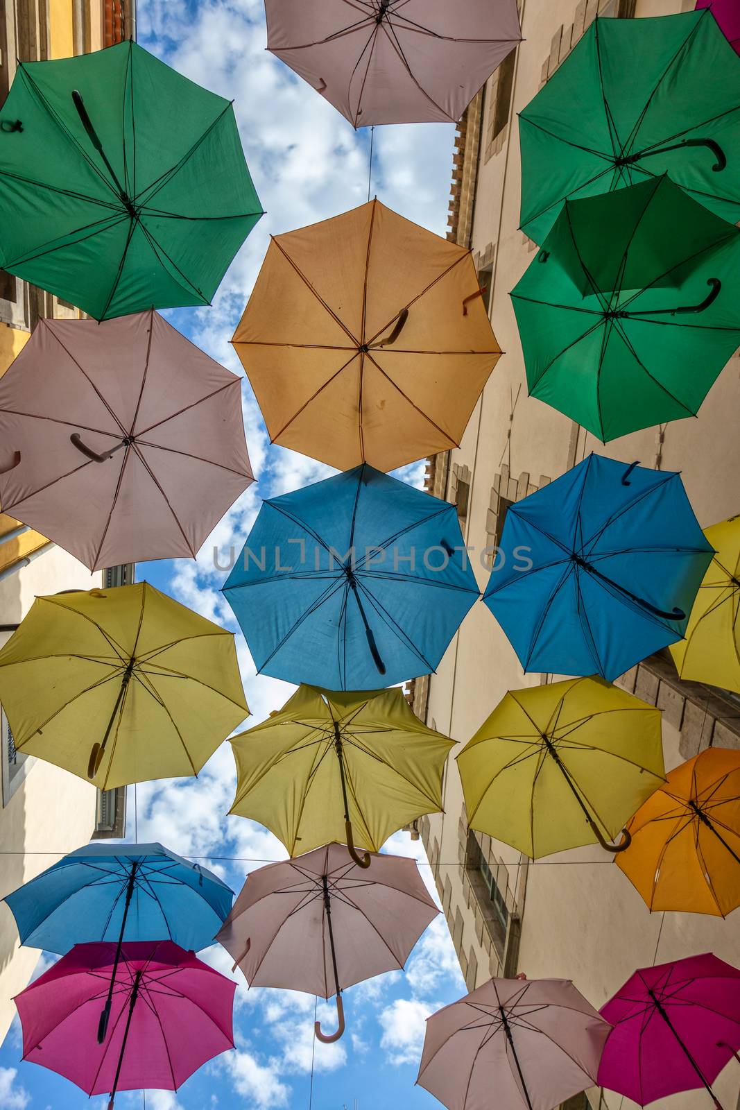 Colorful umbrellas cover a shopping street in Carcassonne, Aude, Occitanie, France