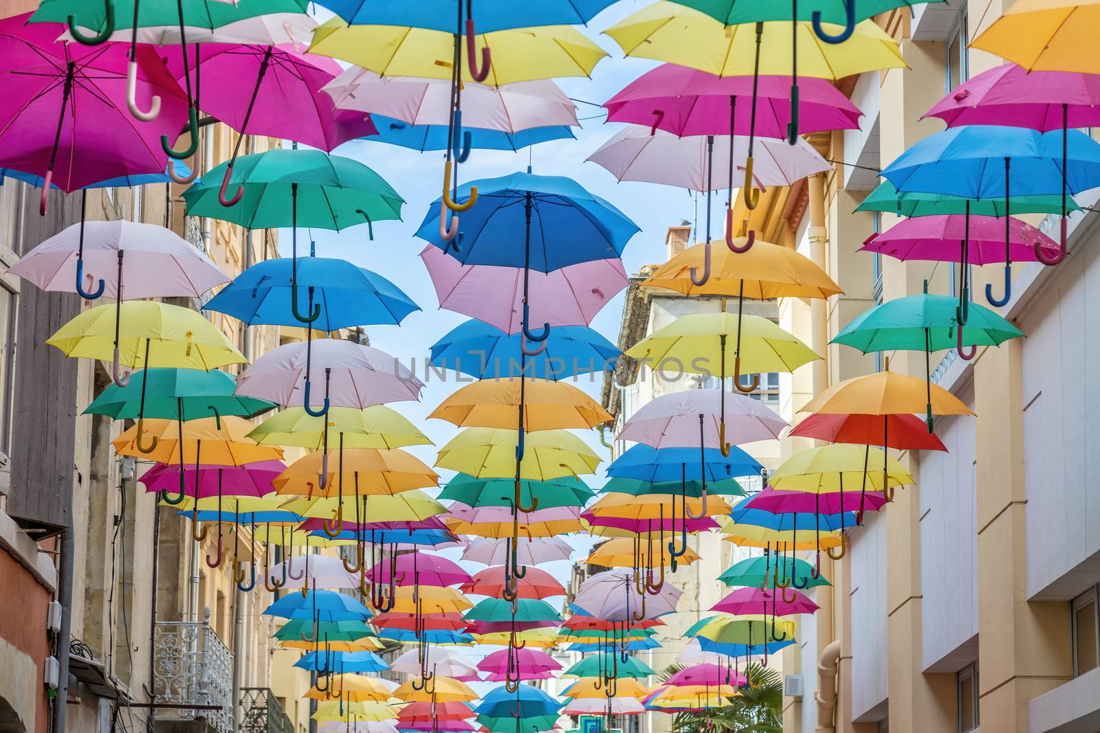 Colorful umbrellas cover a shopping street in Carcassonne, Aude, Occitanie, France by Digoarpi