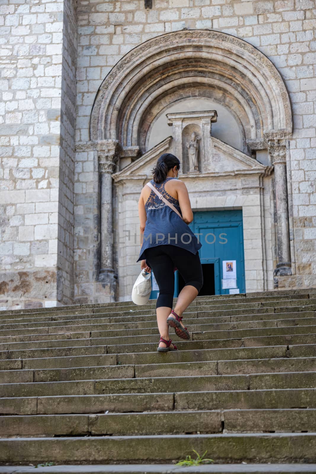 Tourist woman going to the Saint-Salvi Collegiate Church in Albi, France. A World Heritage Site since 2010. by Digoarpi