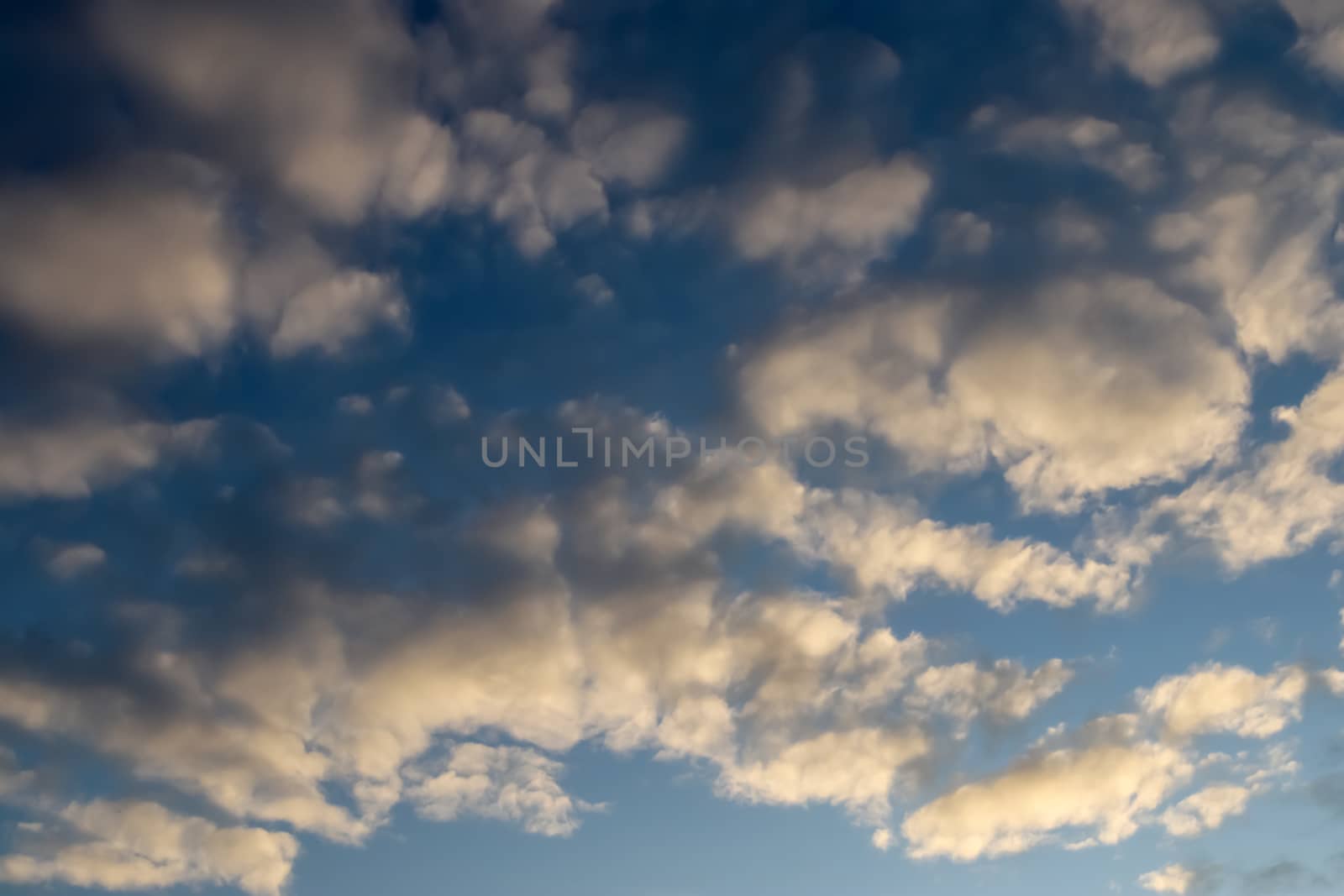 Beautiful panorama of orange and yellow clouds at sunrise and sunset in a blue sky