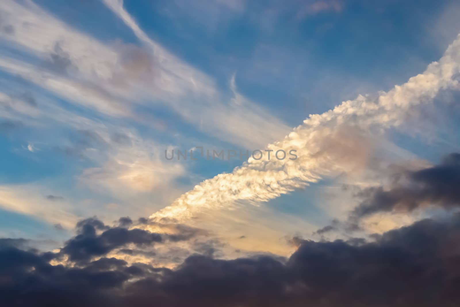 Beautiful panorama of orange and yellow clouds at sunrise and sunset in a blue sky