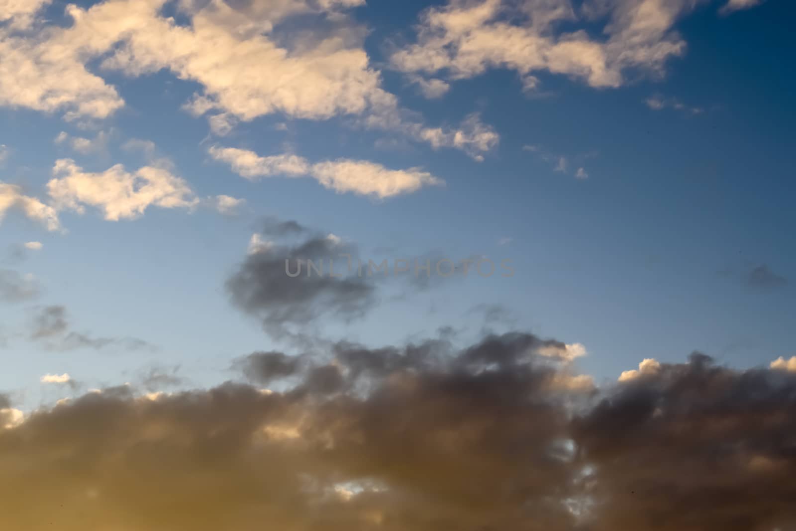 Beautiful panorama of orange and yellow clouds at sunrise and sunset in a blue sky