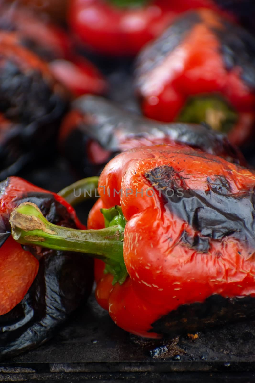 Red peppers roasting on a wood-fired stove in preparation for making ajvar, a traditional serbian dish