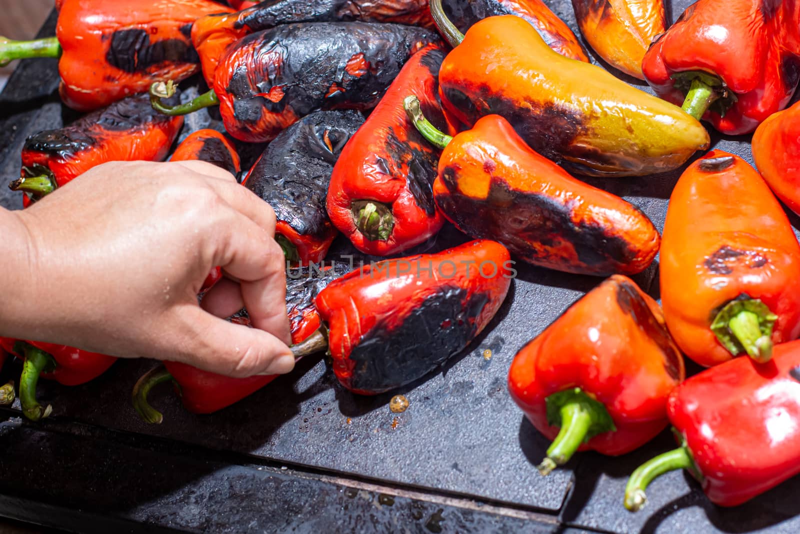 Red peppers roasting on a wood-fired stove in preparation for making ajvar, a traditional serbian dish