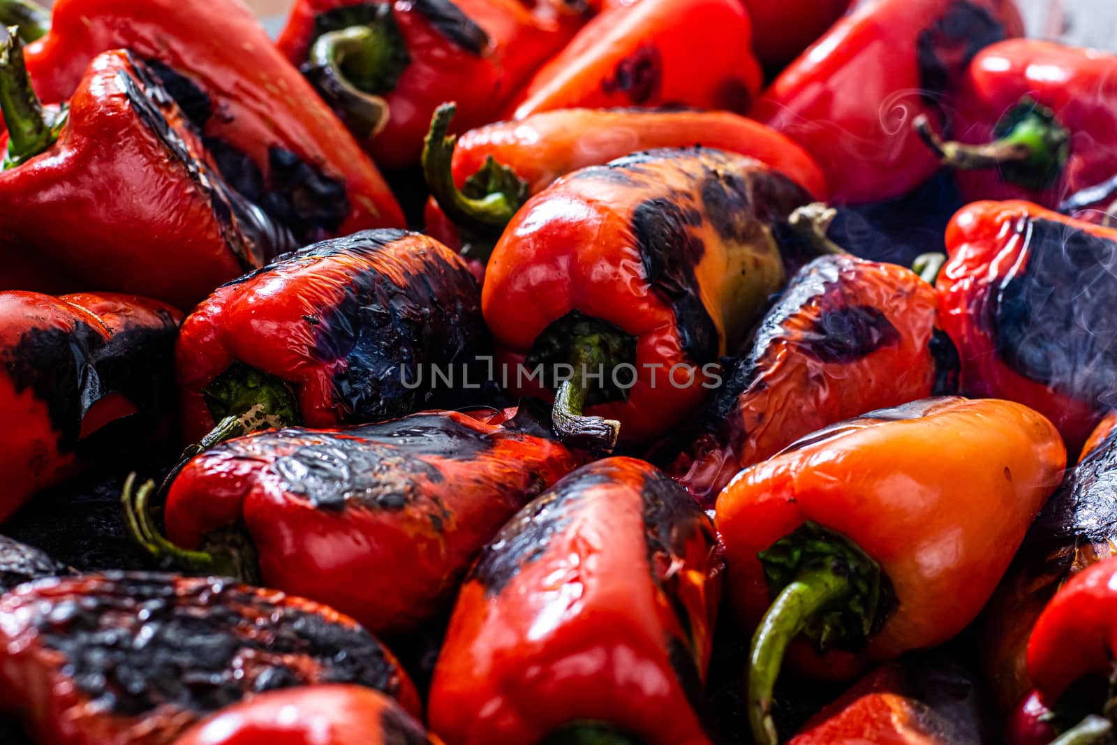 Red peppers roasting on a wood-fired stove in preparation for making ajvar, a traditional serbian dish