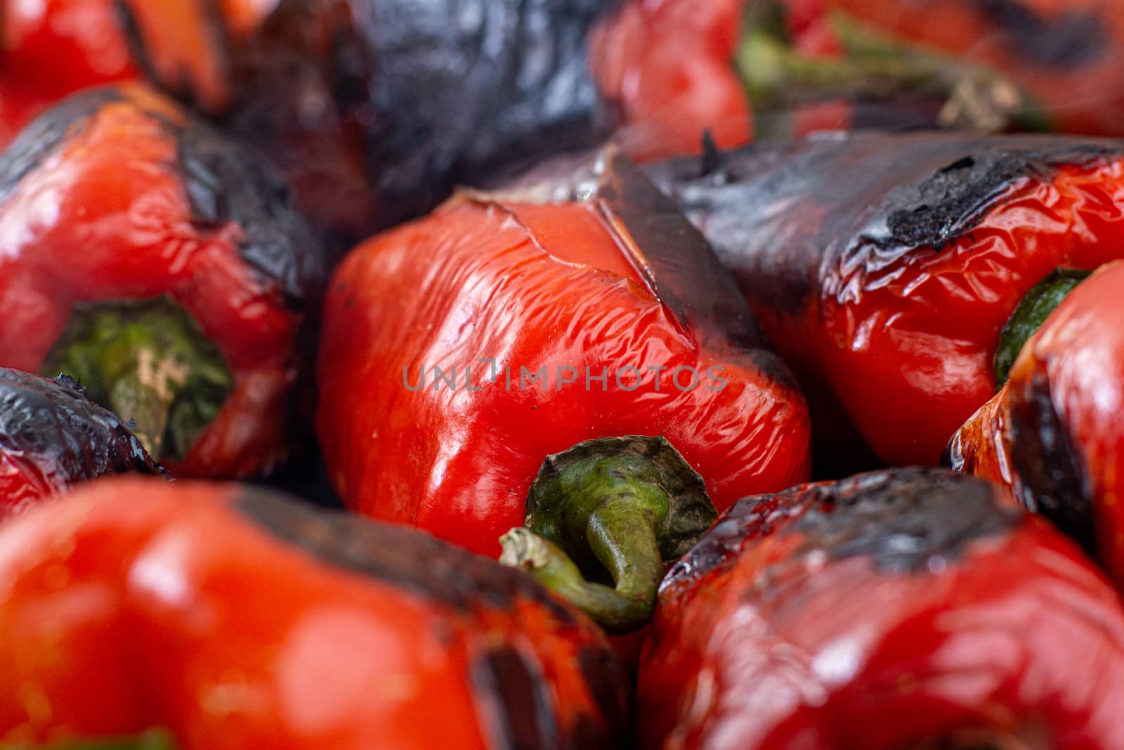 Red peppers roasting on a wood-fired stove in preparation for making ajvar, a traditional serbian dish
