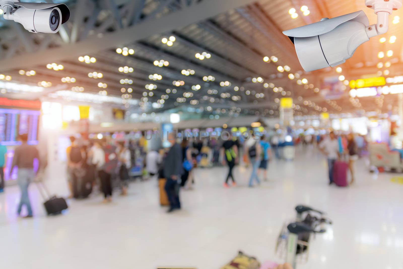 Closeup CCTV security camera on blurred inside the airport terminal background.