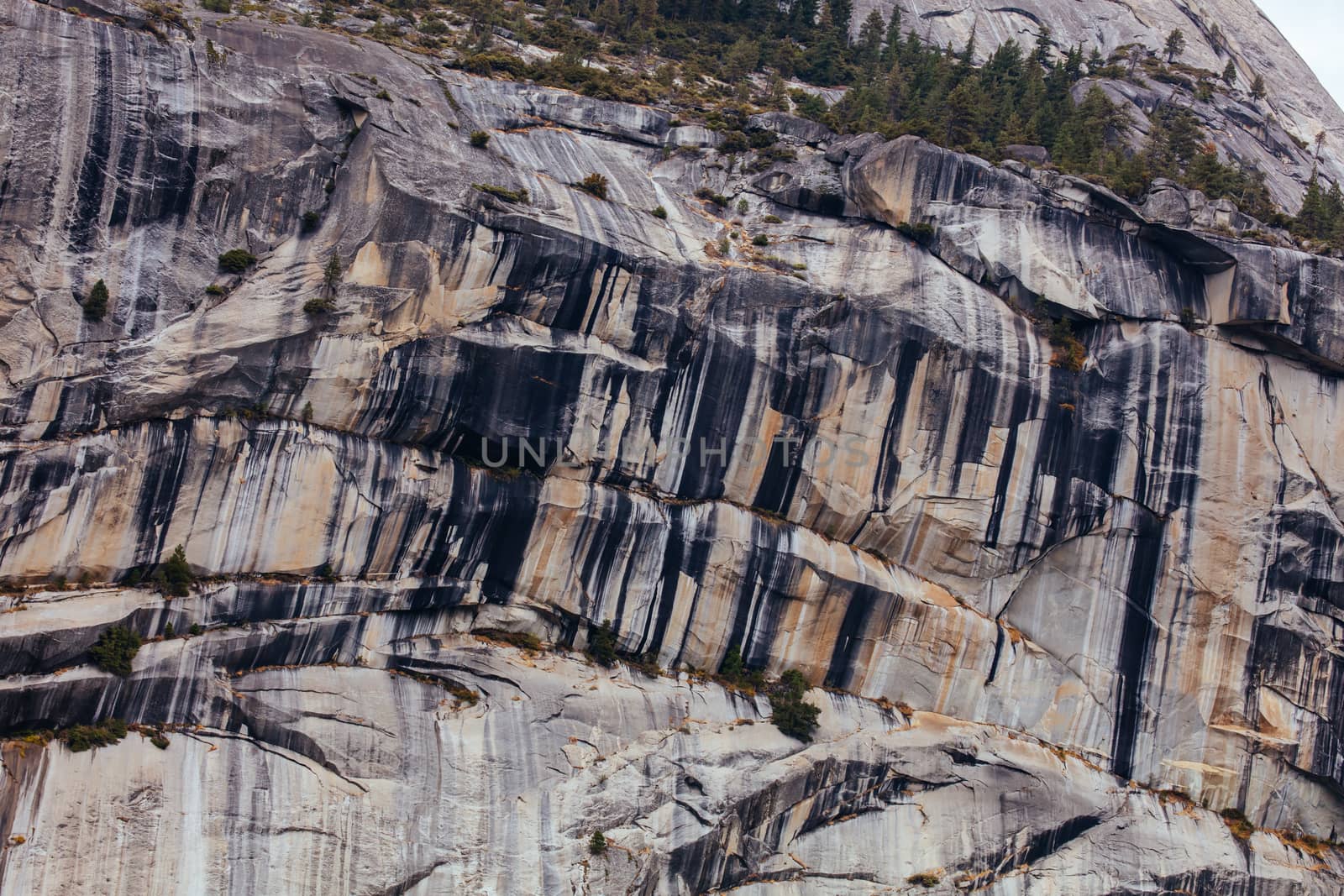 The view from within Yosemite Valley and rock detail of surrounding rock faces on a stormy day in California, USA