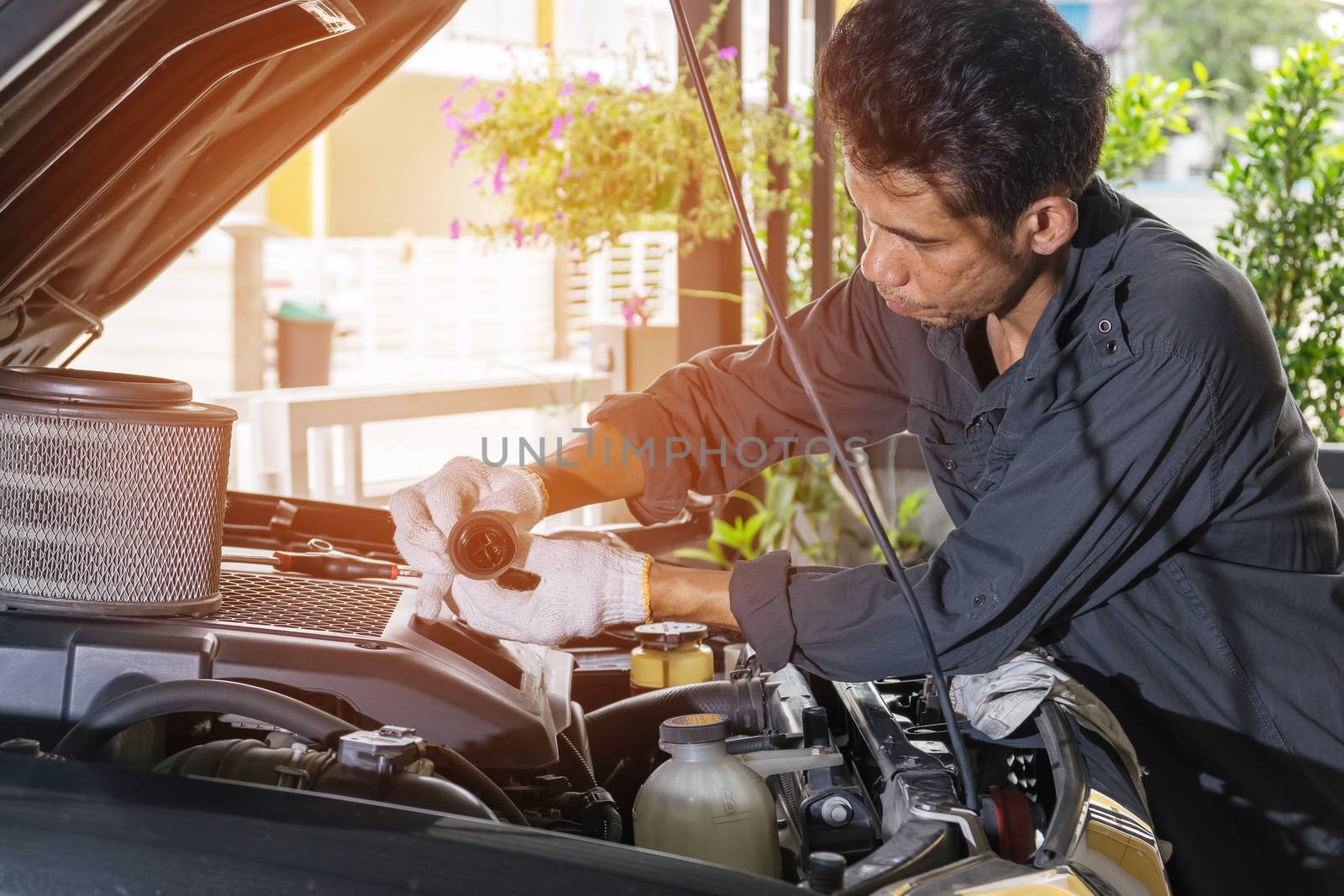 The technician is opening the oil tank of the car to check and repair, Automotive industry and garage concepts.